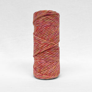 one roll of 4mm mutli coloured macrame string showing yellow pink purple red standing upright on white background