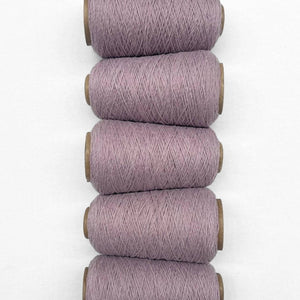 Five cones of iced lilac wool cord laying flat and side by side on white back ground