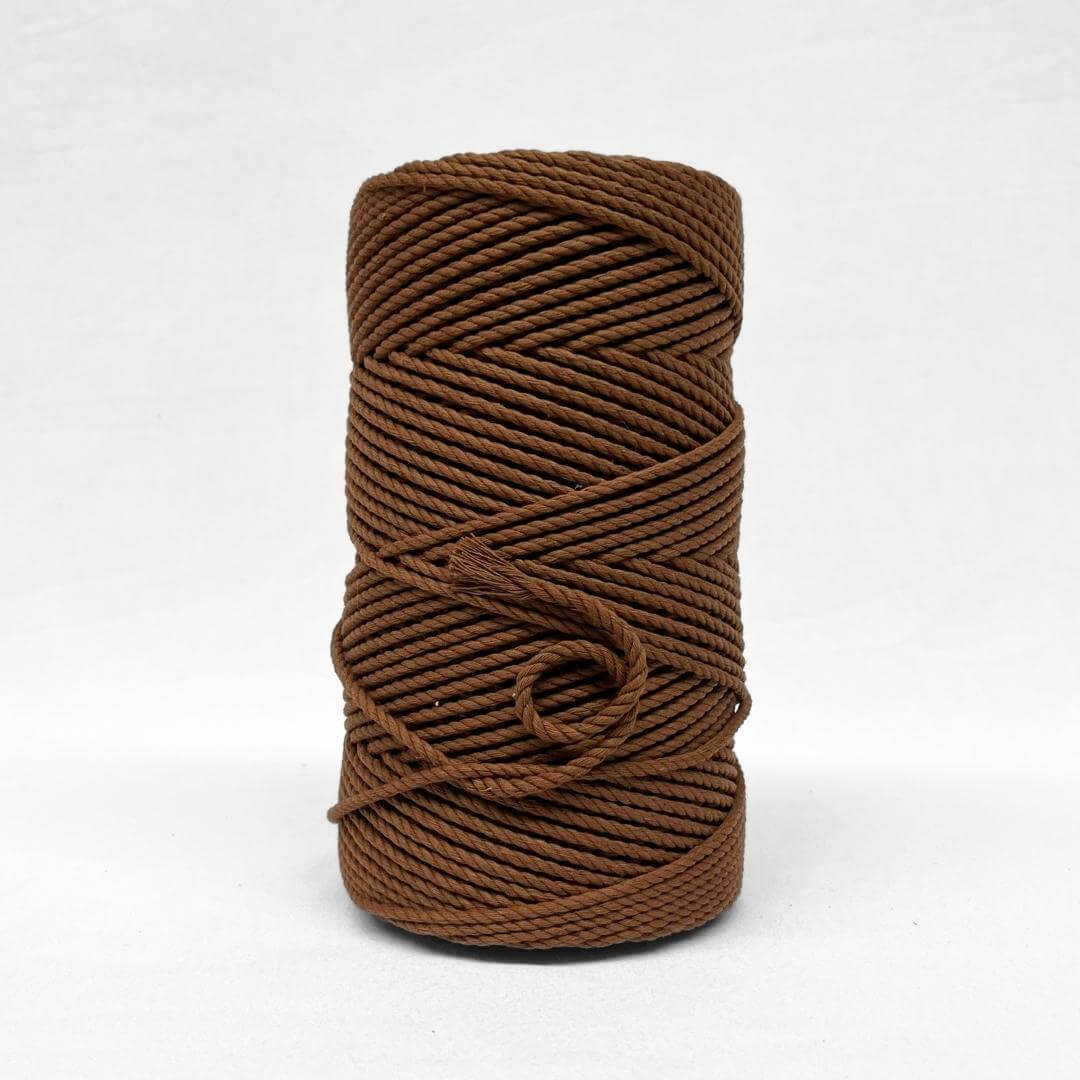 close up image on one roll of deep brown cotton rope 4mm 3ply on white background