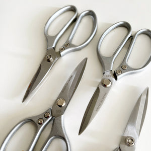 metal scissors in group photo on white wall